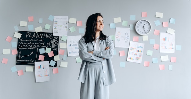 Photo smiling, confident beautiful brunette on the background of the office