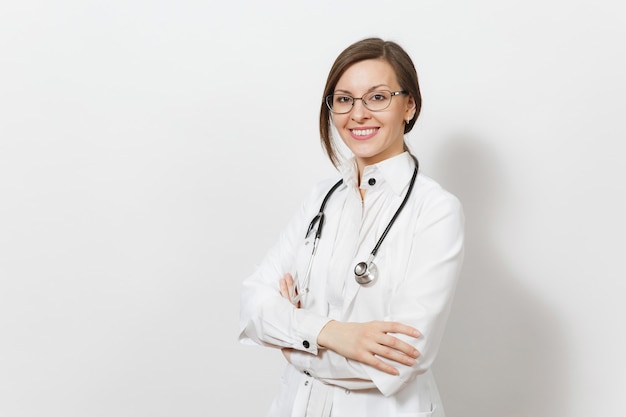 Sorridente fiducioso giovane e bella donna medico con lo stetoscopio, occhiali isolati su sfondo bianco. la dottoressa in abito medico tiene le mani giunte. personale sanitario, salute, concetto di medicina.