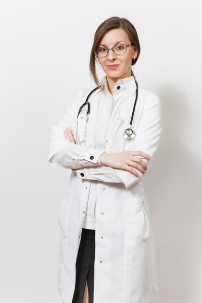 청진 기, 흰색 배경에 고립 된 안경 자신감이 아름 다운 젊은 의사 여자 웃 고. 의료 가운을 입은 여성 의사가 손을 접고 있습니다. 의료 인력, 건강, 의학 개념입니다.