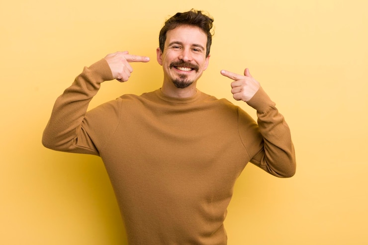 Photo smiling confidently pointing to own broad smile positive relaxed satisfied attitude