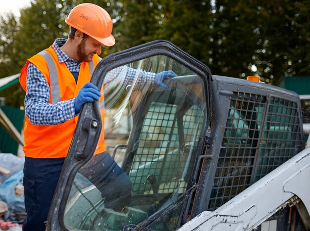 Smiling construction worker driving vehicle sitting in cab. Heavy equipment operator closeup shot