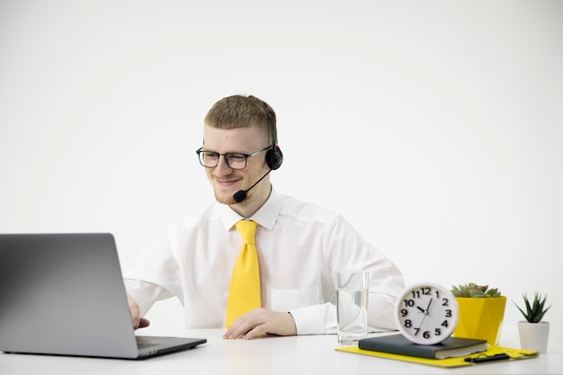 Smiling contact center operator in headphones at desk, online customer support