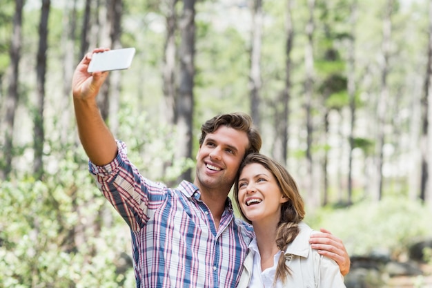 Smiling couple clicking selfie with smart phone 