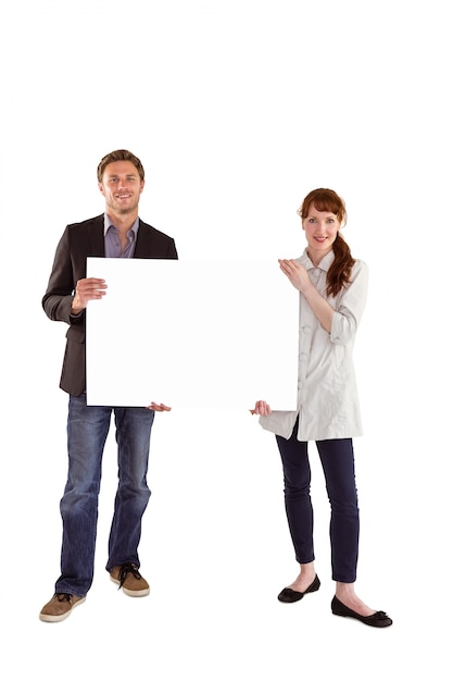 Smiling couple holding large sign