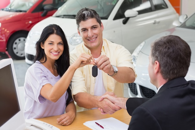 Smiling couple holding their new car key