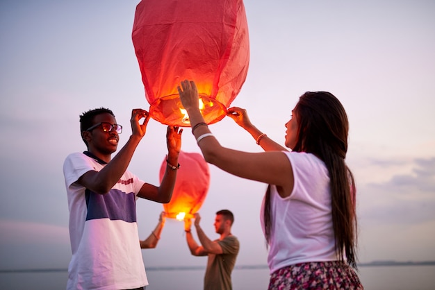 Smiling couple launching Chinese lanterns as symbol of love