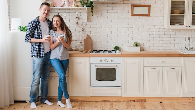 Photo smiling couple in love standing in kitchen