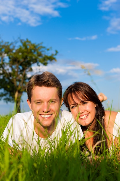 Smiling couple lying in a sunny meadow