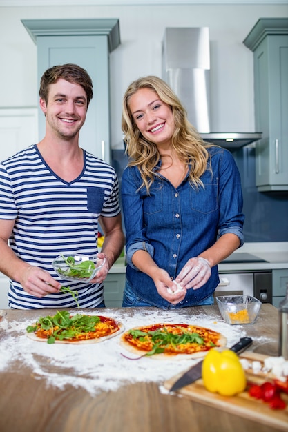 台所でピザを準備する笑顔のカップル