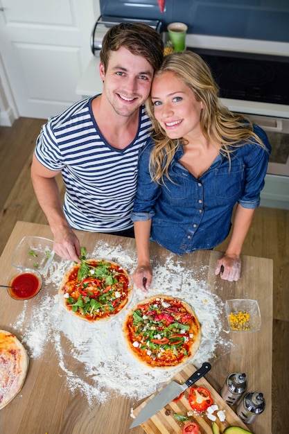 부엌에서 피자를 준비하는 웃는 커플