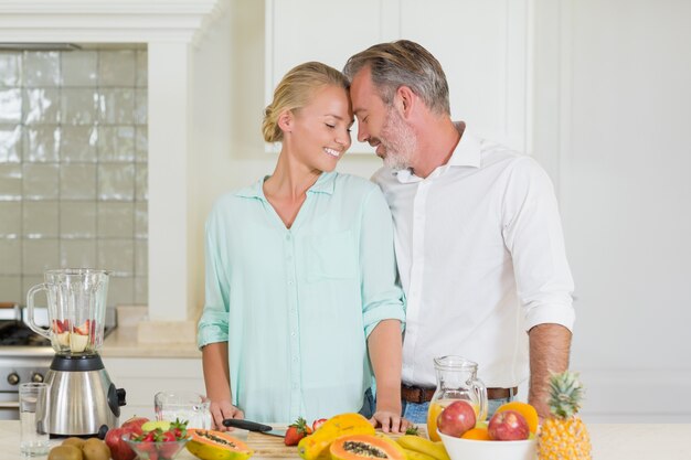 Smiling couple romancing in kitchen