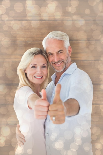 Photo smiling couple showing thumbs up together against light glowing dots design pattern