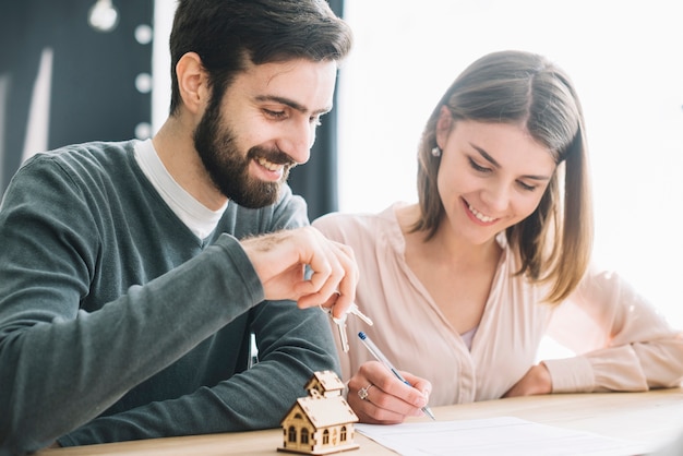 Photo smiling couple signing agreement