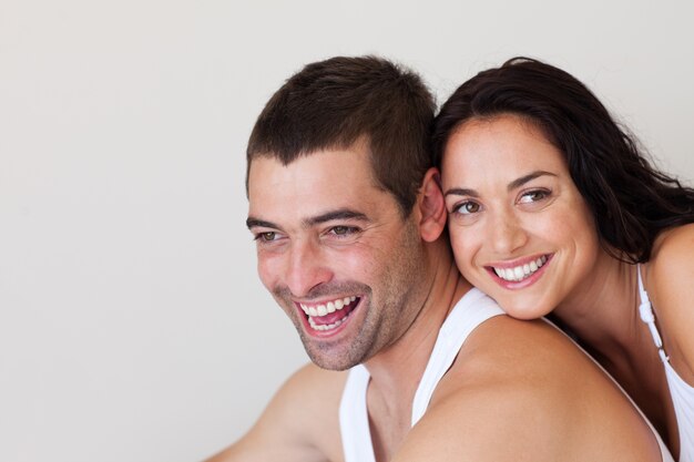 Photo smiling couple sitting on the bed