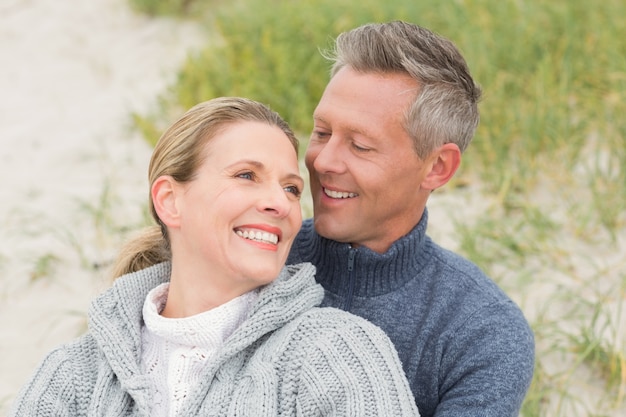 Smiling couple sitting on the sand