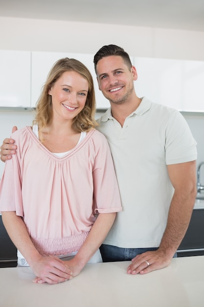 Smiling couple standing at kitchen counter