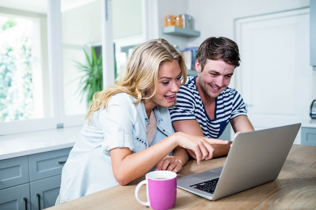 Photo smiling couple typing on laptop at home