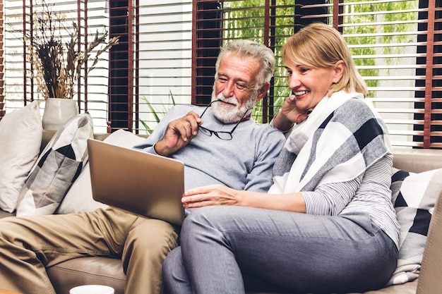 Smiling couple using laptop at home