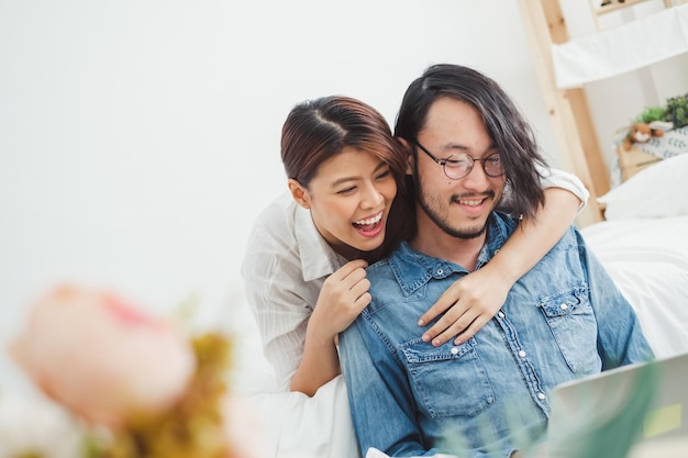 Photo smiling couple using laptop while sitting at home