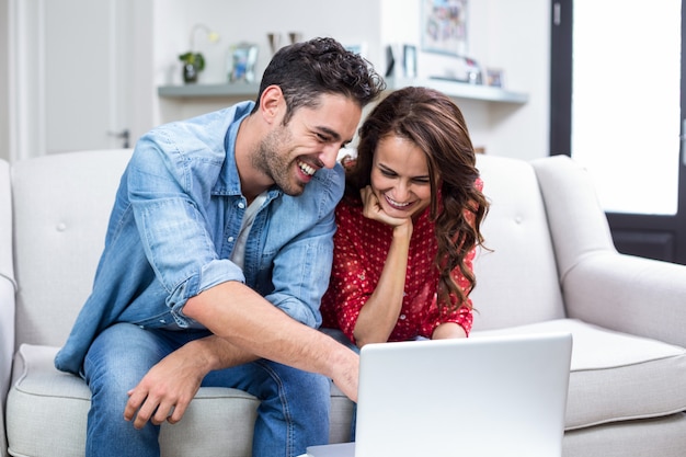 Smiling couple using laptop 