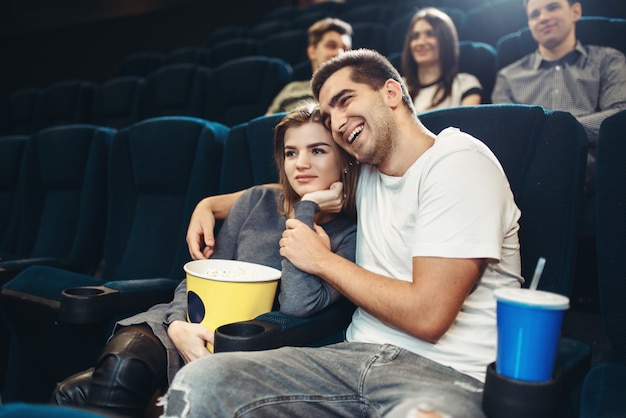 映画館でコメディ映画を見ている笑顔のカップル。ショータイム、エンターテインメント業界