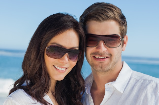 Smiling couple wearing sunglasses and looking at camera