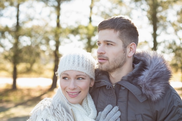 Smiling couple in winter clothing in the woods