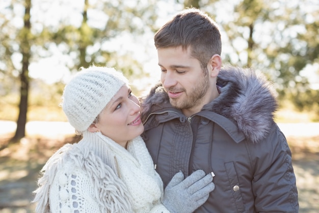 Smiling couple in winter clothing in the woods