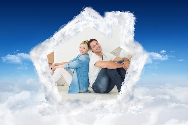 Photo smiling couple with boxes in a new house against bright blue sky over clouds