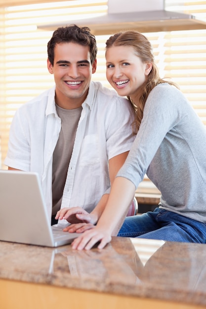 Smiling couple with notebook in the kitchen