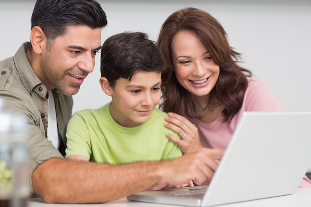 Smiling couple with son using laptop