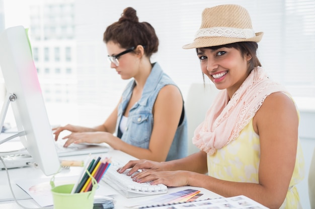 Smiling coworkers typing on keyboard