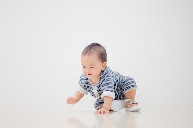 Smiling crawling Asian baby boy at home