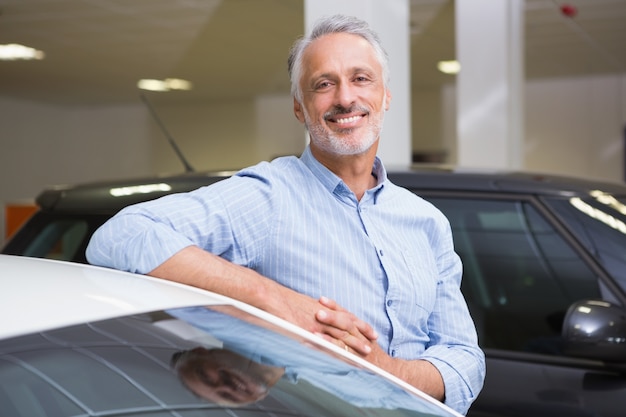 Smiling customer leaning on car