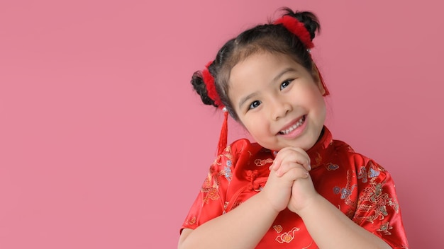 写真 赤い中国の伝統的なドレスでかわいいアジアの小さな女の子の笑顔。幸せな中国の旧正月のコンセプト。