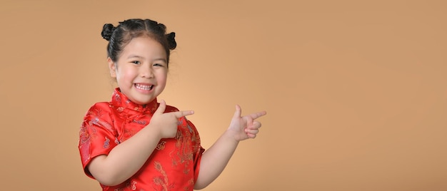 赤い中国の伝統的なドレスでかわいいアジアの小さな女の子の笑顔。幸せな中国の旧正月のコンセプト。