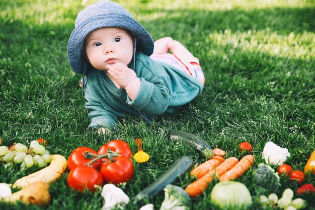 사진 푸른 잔디에 웃는 귀여운 아기와 다른 신선한 과일과 야채