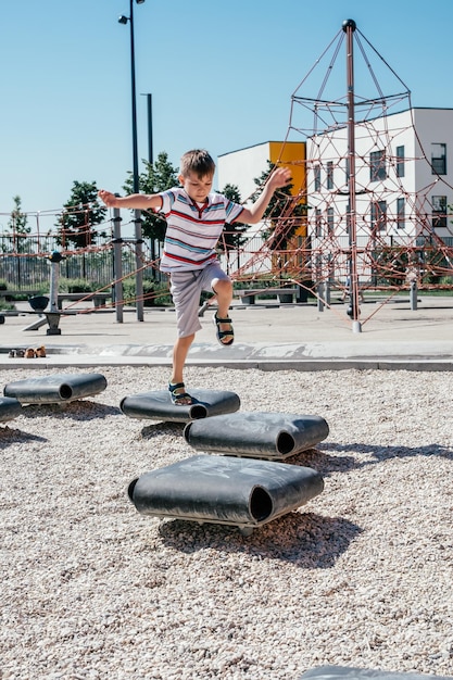 smiling cute boy jumping on a playground