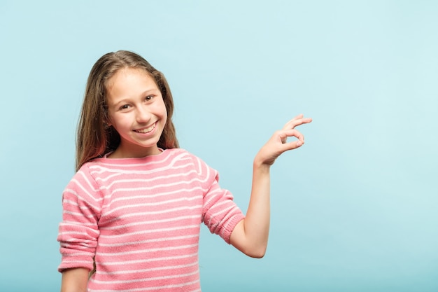 Photo smiling cute girl holding virtual object on invisible string in hands