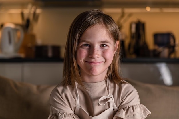 Smiling cute girl at home in the kitchen in an apron