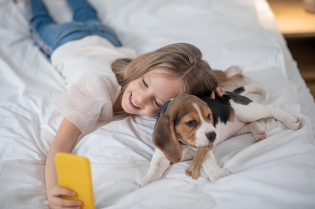 Smiling cute girl making photo with her funny pet