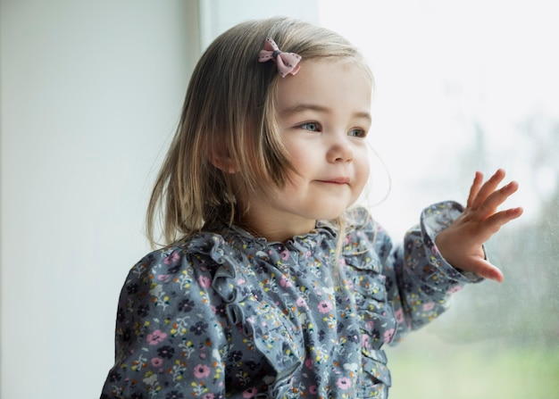 笑顔のかわいい女の子が窓の外を見る