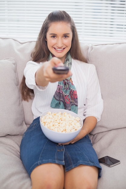 Smiling cute model changing tv channel