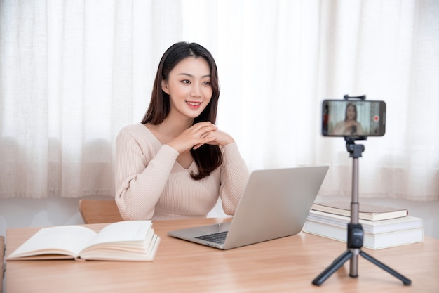 smiling cute young asian woman blogger recording video