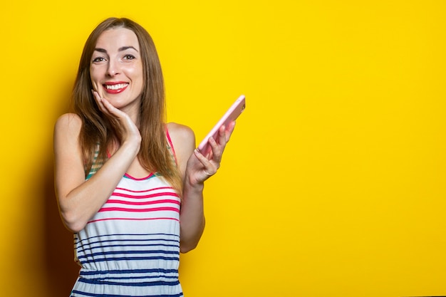 Smiling cute young girl holding a phone