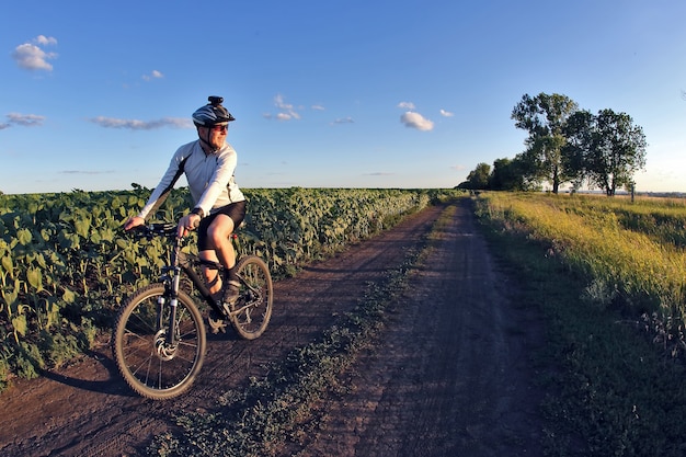 Smiling cyclist rides along a field trail