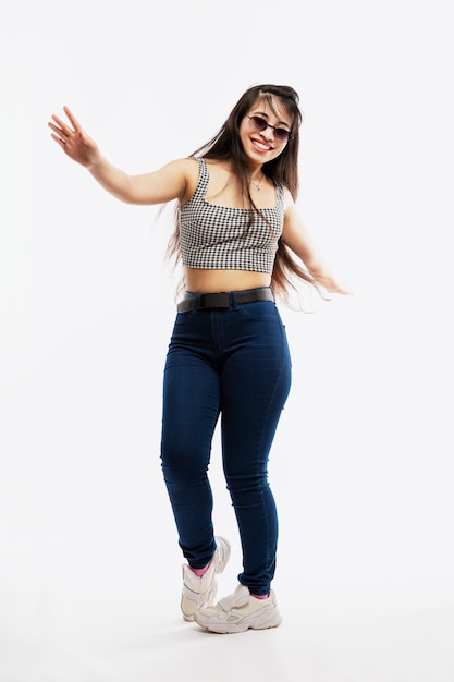 Smiling dancing Young girl in jeans enjoys life. Joy and happiness. Full height.
