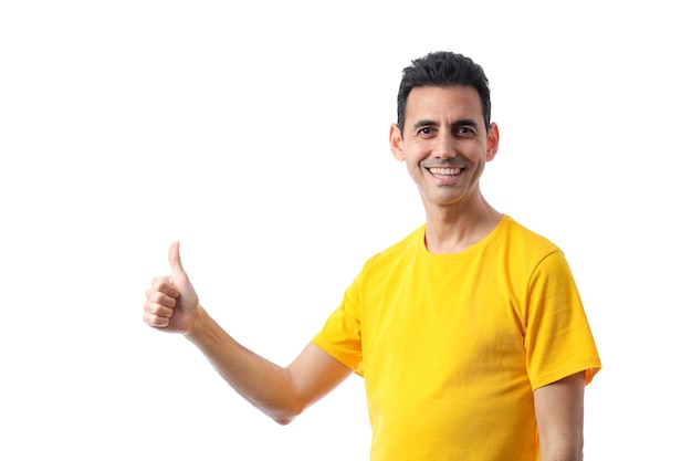 Smiling darkhaired forty year old man in yellow tshirt raising right hand finger on pure white background