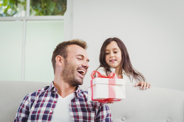 Smiling daughter giving a gift to her father 