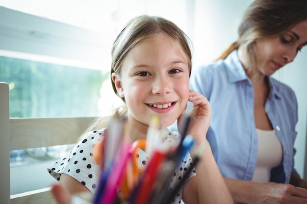 Smiling daughter sitting next to her mother